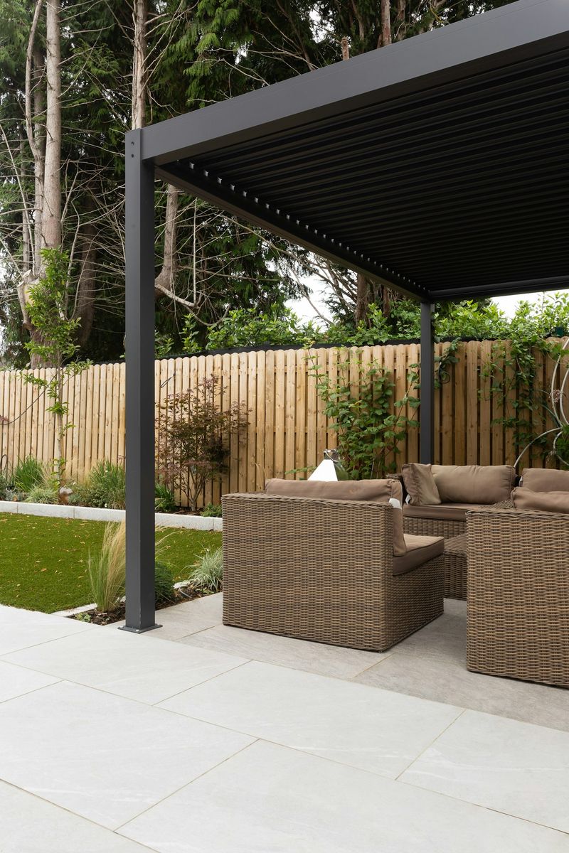 Close-up of aluminum pergola louvers rotated closed, showing the solid slat roofline and support post