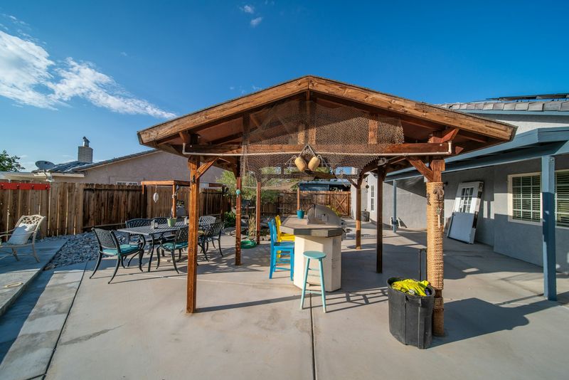 Patio lounge seating arranged under a covered aluminum structure